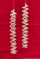 Full view of both glass spiral icicles against red background