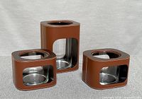 Set showing one tall and two low leather-wrapped glass vases