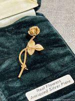 Brooch close-up inside velvet box showing rose design and label Real Flowers Antiqued Silver Plate