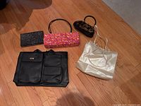 All five handbags arranged on floor