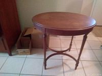 Full view of the antique oval wood side table showing top surface and overall structure.