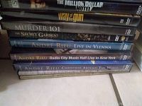 Stack of DVDs including The Million Dollar Hotel, Way of the Gun, Murder 101, The Secret Garden, and Andre Rieu concert DVDs.