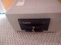 Close-up front view of the Sentry 1150 portable safe showing the locking key and handle.