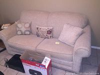Full view of La-Z-Boy sleeper sofa with three decorative pillows and box placed in front