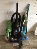 Full view of Dirt Devil vacuum, Bissell wet mop, two dusters and carpet sweeper with pads grouped together