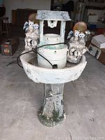 Front view of the whole fountain showing the rustic well design with two owls, water orb, and pedestal stand