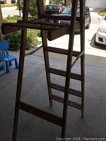 Side view of the wooden step ladder showing steps and top tray.