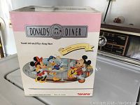 Front view of Disney Donald's Diner toy box showing the illustrated characters Mickey, Minnie and Donald with product name and brand Takara.