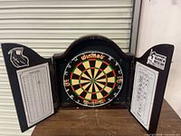 Cabinet open showing dartboard, scoring boards and out-chart