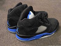 Side view of both sneakers showing suede uppers, mesh panels, midsole colour