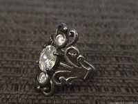 Front view showing three clear stones and filigree setting