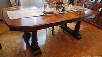 Full view of rectangular solid wood dining table with pedestal base