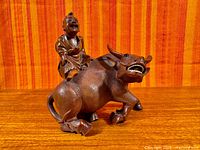 Full view of hardwood sculpture showing boy on water buffalo