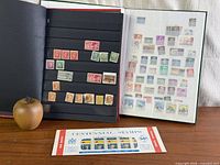 Two stamp albums opened displaying mounted stamps and Centennial souvenir pane