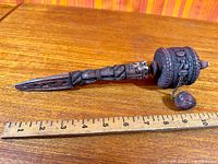 Full view of prayer wheel beside ruler showing length