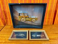 All three framed watch-part car collages on display