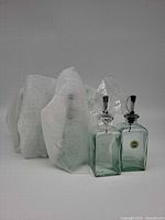 Both glass dispenser bottles side by side with protective wrap