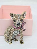Front view of Chihuahua brooch against pink box
