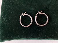 Pair of sterling silver hoop earrings on dark background