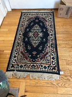 Large navy blue oriental style area rug with floral medallion and border pattern, fringed ends