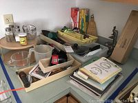 Photo showing various kitchen utensils, measuring cups, salt and pepper shakers, and more on a countertop.