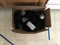 Box with black dinnerware showing multiple plates and bowls stacked inside.