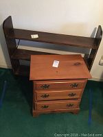 Overall view of wooden shelf and night stand together on floor with visible wear on shelf finish.