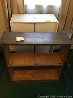 Front view showing white cabinet with doors behind wooden shelving unit