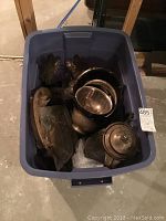 Bin view showing multiple silver plate items including coffee pot, bowls, and other pieces packed in a blue plastic tub.