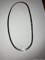 Full view of the sterling silver herringbone chain laid flat