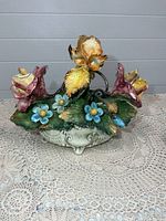Front view of porcelain floral centerpiece showing arrangement and base