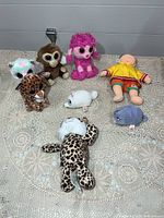 Group view of all eight plush items laid out on crocheted surface