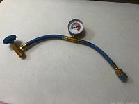 Full view of blue Duracool service hose with gauge and fittings
