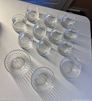 All 13 glass pieces laid out: 10 tumblers, 2 dessert bowls, 1 handled bowl