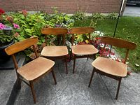 All four teak dining chairs front angle