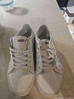 Top view of both sneakers showing white uppers, laces, and Vans tongue labels