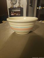 Side view of cream ceramic bowl with pastel stripes