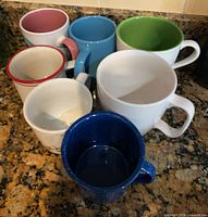 Group shot of seven assorted mugs on countertop
