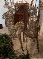 Two grapevine deer figures standing next to mirror