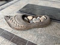 Side angle of wooden clog bowl filled with river rocks
