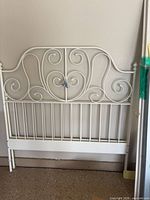 White wrought iron headboard with scrollwork
