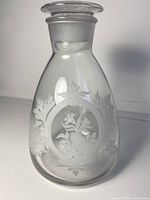 Full view of clear glass decanter showing etched floral medallion design