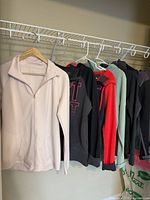 Six athletic tops hanging on rack