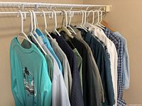 Side view of clothing rack showing variety of shirts on hangers