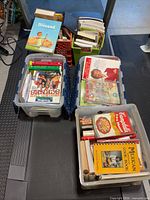 Overview of three totes filled with assorted cookbooks, health and self-help books on treadmill