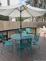 Dining table, four chairs, umbrella assembled on deck