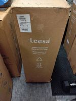 Front view of Leesa boxed mattress, branding visible