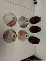 Top view of three pastel swirled lamp shades and three amber vases