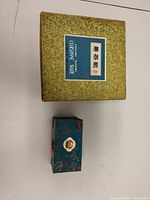 closed green brocade cloisonné box and teal Baoding ball box
