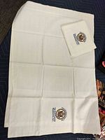 Complete view of one unfolded pillow sham and second folded sham showing embroidery
